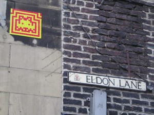 High on a wall is this yellow and red Space Invader High on a wall is this yellow and red Space Invader